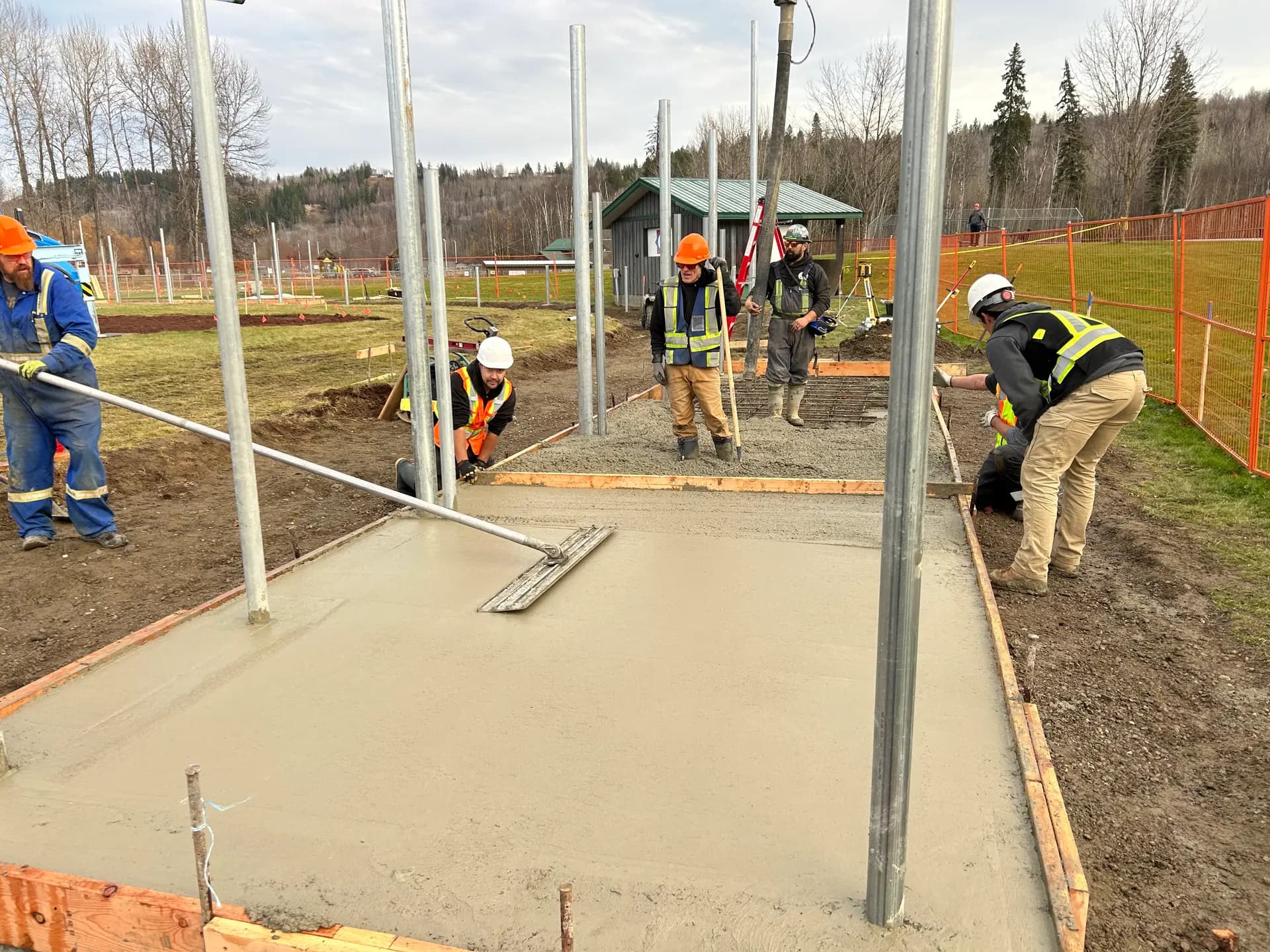 Concrete crew screeding a fresh structural pad pour