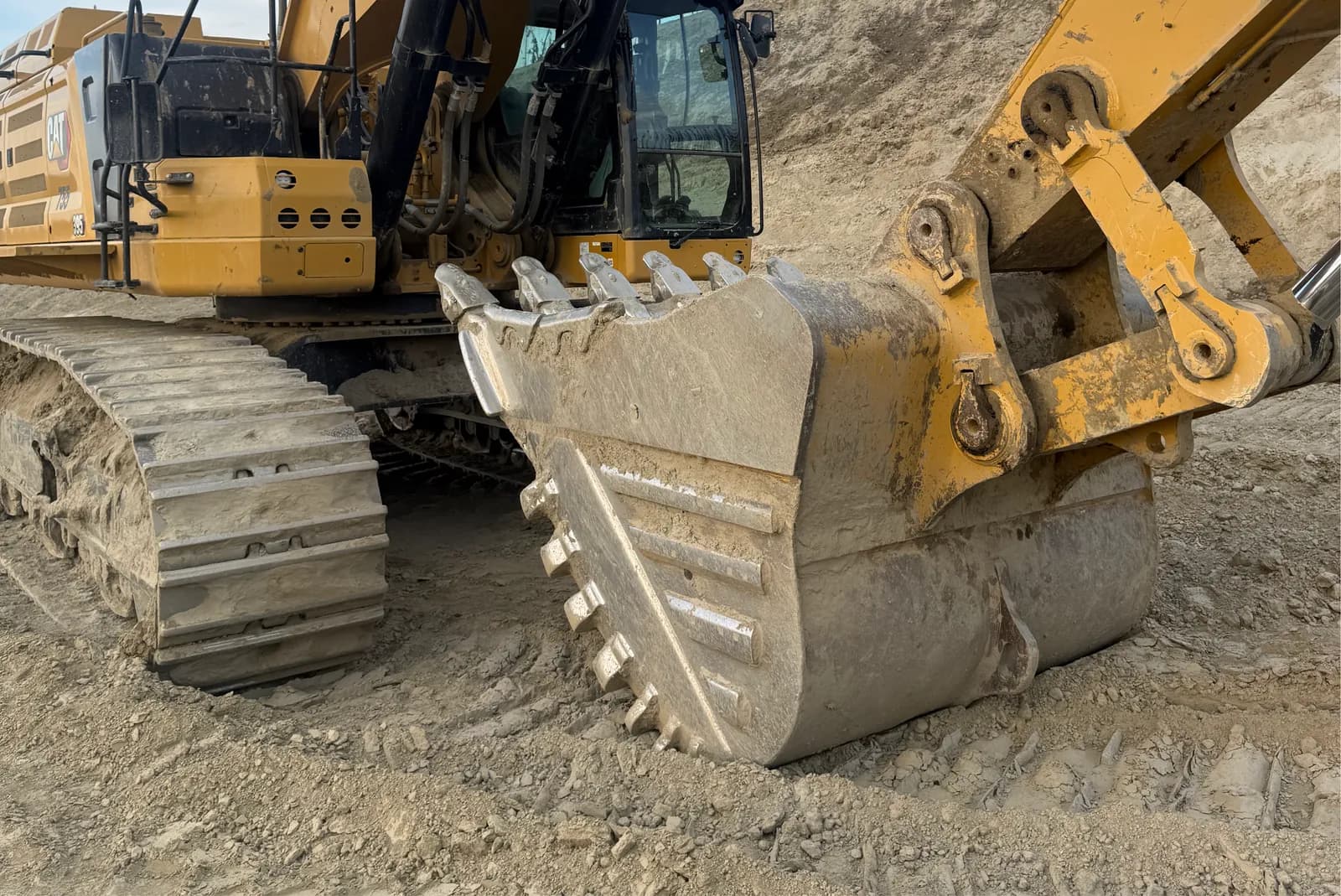 Large tracked excavator with a heavy bucket building road subgrade on a resource site