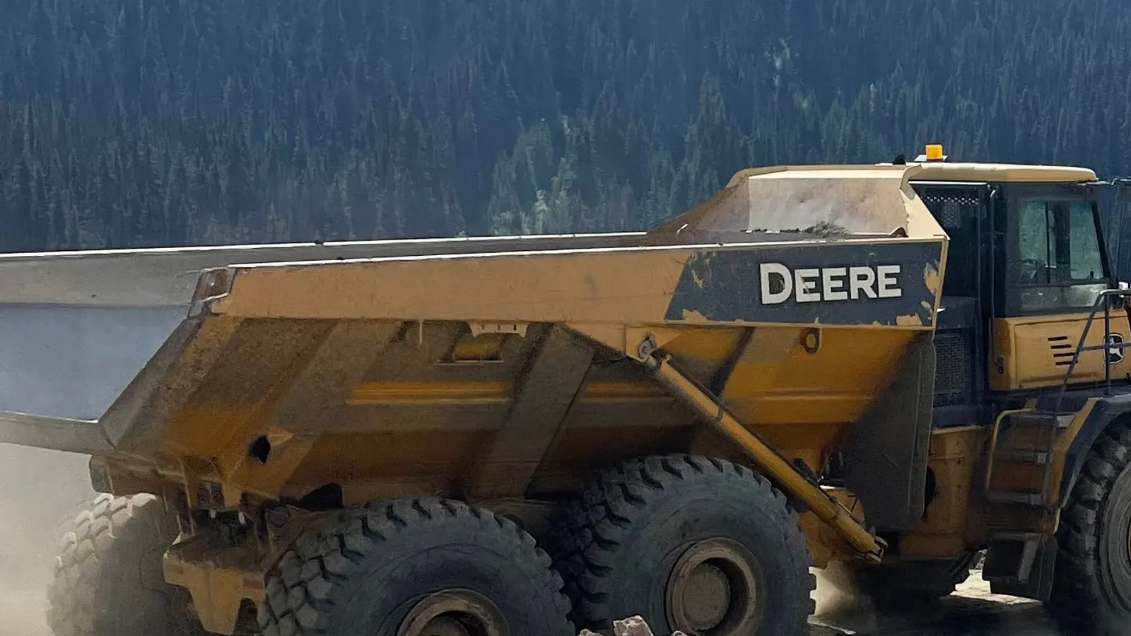 Articulated rock truck hauling material on a resource site road in the Northern BC mountains