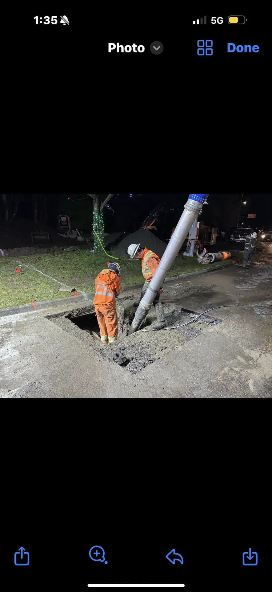 Crew placing concrete around a manhole during night works