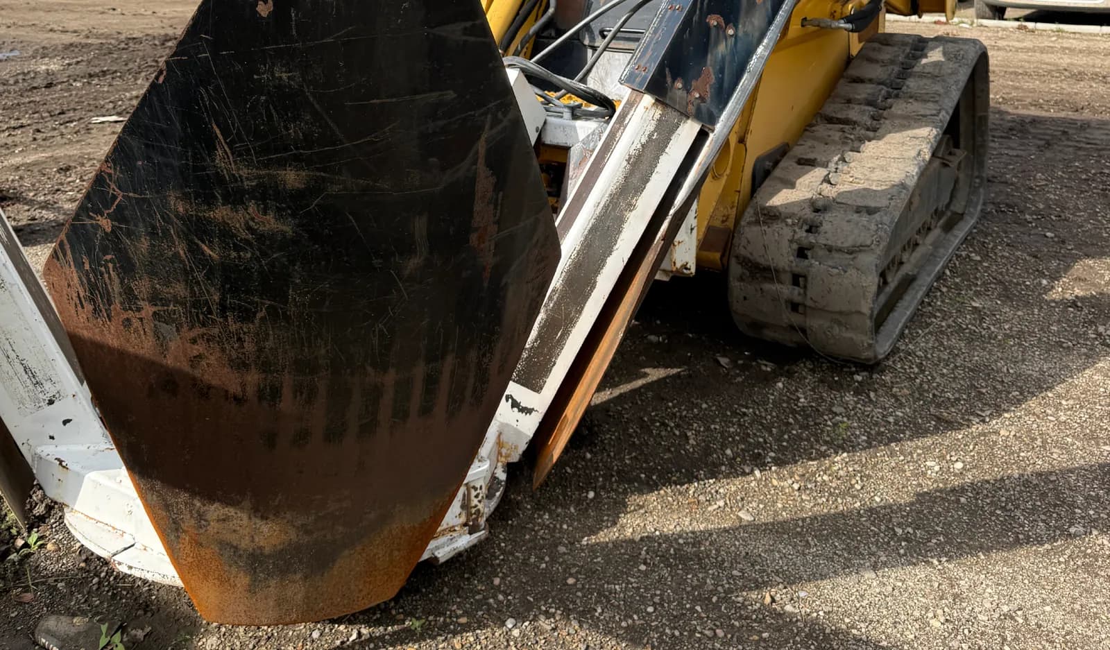 Compact track loader with a front attachment on a gravel yard, part of a Vancouver Island excavation fleet