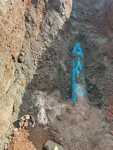 Open trench exposing a marked water service during utility upgrades
